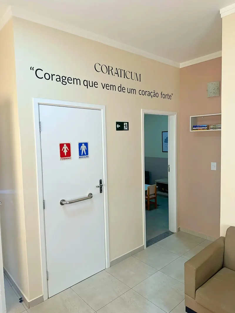 Corredor da Clínica Coraticum com frase 'Coragem que vem de um coração forte'
